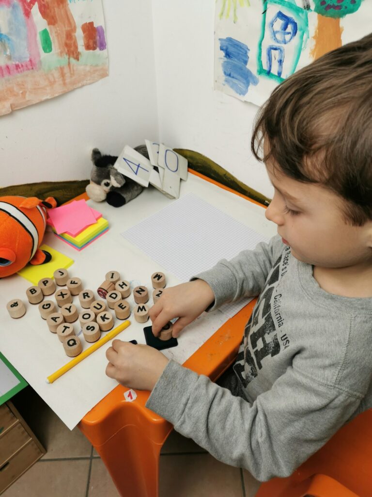 Preschool boy plays with letters.