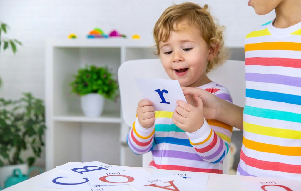 The child learns English letters. Selective focus.